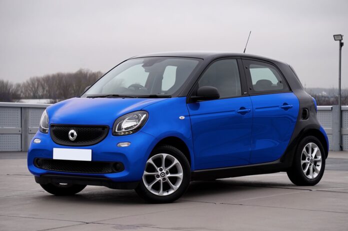 Niebieski Smart Forfour zaparkowany na tle miejskich budynków