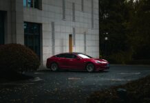Czerwony luksusowy samochód elektryczny przy nowoczesnym budynku